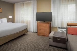 a hotel room with a bed and a flat screen tv at TownePlace Suites by Marriott Portland Hillsboro in Hillsboro