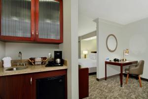 Habitación de hotel con lavabo y dormitorio en SpringHill Suites Chesapeake Greenbrier en Chesapeake