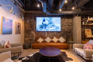 a living room with a couch and a large screen at Moxy Nashville Downtown in Nashville