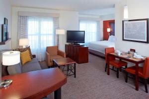 クリアウォーターにあるResidence Inn by Marriot Clearwater Downtownのベッドとリビングルームが備わるホテルルームです。