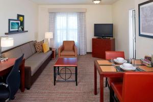 a living room with a couch and a tv at Residence Inn by Marriot Clearwater Downtown in Clearwater