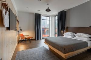 a bedroom with a bed and a large window at Moxy Nashville Downtown in Nashville