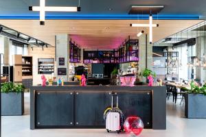 a lobby with a bar with a luggage at Moxy Utrecht in Utrecht