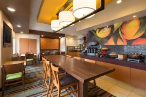 ein Restaurant mit einem großen Holztisch und Stühlen in der Unterkunft Fairfield Inn & Suites Bismarck South in Bismarck