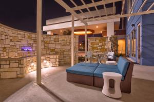 a patio with a blue couch and a stone wall at SpringHill Suites by Marriott Houston I-45 North in Houston