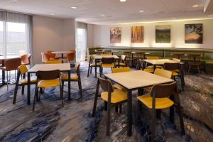 a dining room with tables and yellow chairs at Fairfield Inn & Suites by Marriott Cedar Rapids in Cedar Rapids