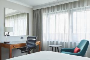 a hotel room with a bed and a desk and chairs at Portsmouth Marriott Hotel in Portsmouth