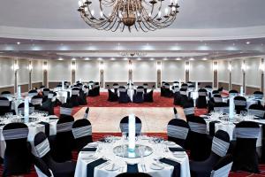 ポーツマスにあるポーツマス マリオット ホテルのテーブルと椅子、シャンデリアのある宴会場