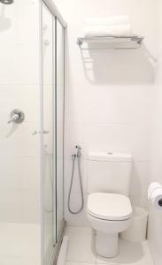 a white bathroom with a toilet and a shower at Pena Branca Hotel e Eventos in Santo Antônio de Jesus