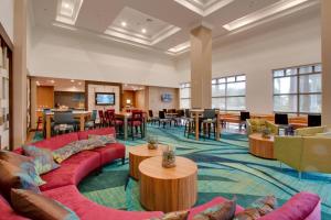 a lobby with couches and tables and a cafeteria at SpringHill Suites by Marriott Orlando Lake Buena Vista South in Kissimmee