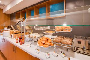 a bakery counter with pastries and bread on it at SpringHill Suites by Marriott Orlando Lake Buena Vista South in Kissimmee