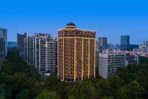 um edifício alto com luzes acesas numa cidade em Fairfield by Marriott Hangzhou Xihu District em Hangzhou