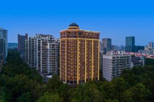 un grand bâtiment éclairé dans une ville dans l'établissement Fairfield by Marriott Hangzhou Xihu District, à Hangzhou