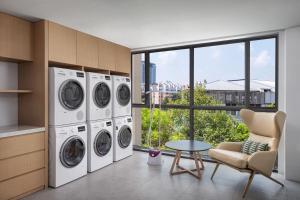 a laundry room with three washing machines and a table at Fairfield by Marriott Hangzhou Xihu District in Hangzhou