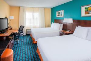 a hotel room with two beds and a flat screen tv at Fairfield Inn & Suites Chicago Tinley Park in Tinley Park
