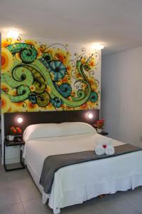 - une chambre avec un lit orné d'une peinture murale dans l'établissement Villa dos Graffitis Pousada, à Morro de São Paulo