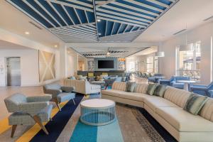 un soggiorno con divani, sedie e TV di SpringHill Suites by Marriott Amelia Island ad Amelia Island