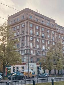 華沙的住宿－Soul Apartment，一座大型建筑,前面有汽车停放