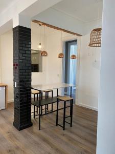ein Esszimmer mit einem Tisch und einer schwarzen Backsteinsäule in der Unterkunft Gorgeous apartment San Telmo up to 6 people in Buenos Aires