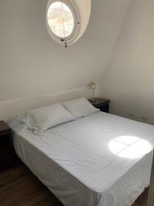 a bedroom with a white bed with a window at Gorgeous apartment San Telmo up to 6 people in Buenos Aires