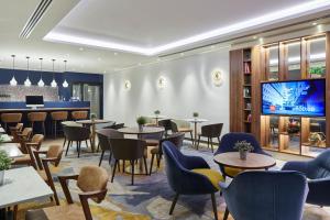 فندق كارديف ماريوت في كارديف: مطعم به طاولات وكراسي وتلفزيون