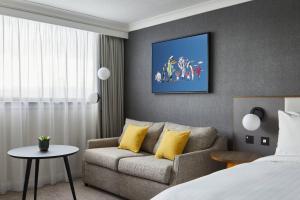 a living room with a couch and a bed at Cardiff Marriott Hotel in Cardiff