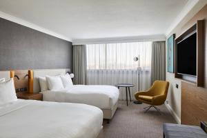 a hotel room with two beds and a television at Cardiff Marriott Hotel in Cardiff
