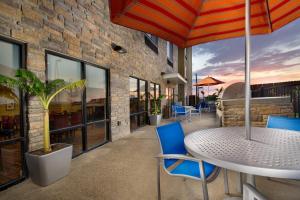 un patio con mesa, sillas y sombrilla en TownePlace Suites by Marriott Eagle Pass, en Eagle Pass