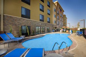 a pool at a hotel with chairs and a building at TownePlace Suites by Marriott Eagle Pass in Eagle Pass
