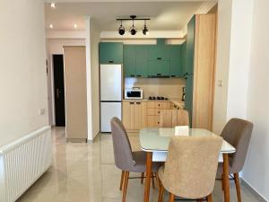 eine Küche und ein Esszimmer mit einem Tisch und Stühlen in der Unterkunft City Heart Luxury Apartment in Kutaissi