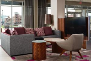 a living room with a couch and a tv at Courtyard by Marriott Rome in Rome