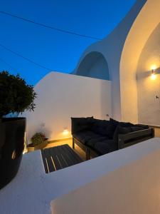 un soggiorno con divano su una parete bianca di Villa Sertis Santorini a Imerovigli