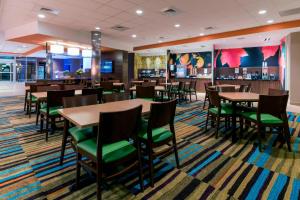 a dining room with tables and chairs and a bar at Fairfield Inn & Suites by Marriott Boston Marlborough/Apex Center in Marlborough