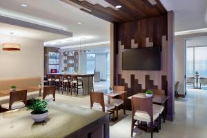 a restaurant with tables and chairs and a flat screen tv at Marriott Birmingham Grandview in Birmingham