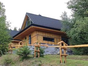 una cabaña de madera con techo de gambrel en Domki Krynica, en Krynica-Zdrój
