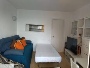 un soggiorno con divano blu e TV di Apartamento con vistas al mar a Las Canteras