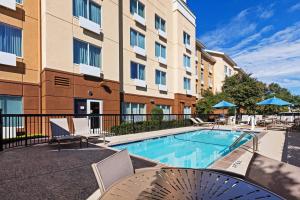 uma piscina com cadeiras e um edifício em Fairfield Inn and Suites by Marriott Austin Northwest/The Domain Area em Austin