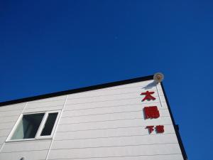 a white building with red bows on the side of it at Abashirikai no Taiyo - Vacation STAY 14415 in Abashiri