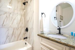 a white bathroom with a sink and a mirror at Orem Vacation Rental Apartment Near BYU Campus! in Orem