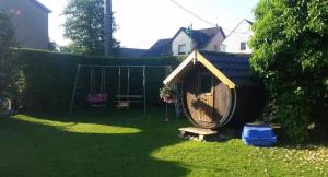 a dog house and a swing in a yard at Tolles Appartement in Gehren mit Garten, Terrasse und Grill in Heideblick