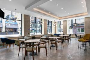 a restaurant with tables and chairs and windows at TownePlace Suites by Marriott Cincinnati Downtown in Cincinnati