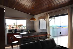 a living room with a kitchen and a table with chairs at Fiorelli 401 in Cunha
