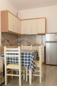 a kitchen with a table and chairs and a refrigerator at Tophill Apartments in Borsh