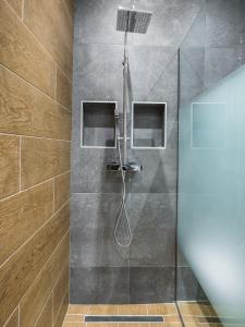 a shower with a shower head in a bathroom at Lorenzo Mavili Suite in Corfu Town