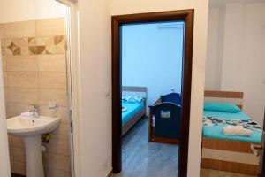 a bathroom with a sink and a bedroom with a bed at Tophill Apartments in Borsh +67 photos