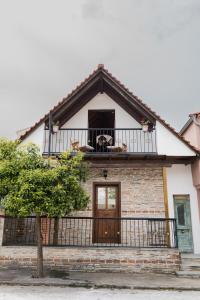 Tianna House في إيراكليتسا: منزل مع شرفة مع كلب على الشرفة