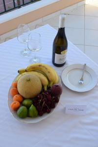 a plate of fruit on a table with a bottle of wine at CASA DEL MARE in Lixouri