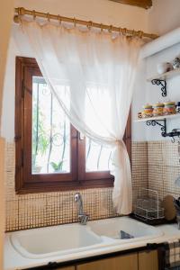 une cuisine avec un évier et une fenêtre dans l'établissement Tianna House, à Nea Iraklitsa