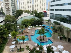 uma vista sobre uma piscina do hotel com guarda-sóis e cadeiras em Mar Hotel Conventions no Recife