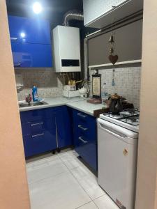a kitchen with blue cabinets and a white stove top oven at Bosphorus waterfront - trendiest location in Istanbul